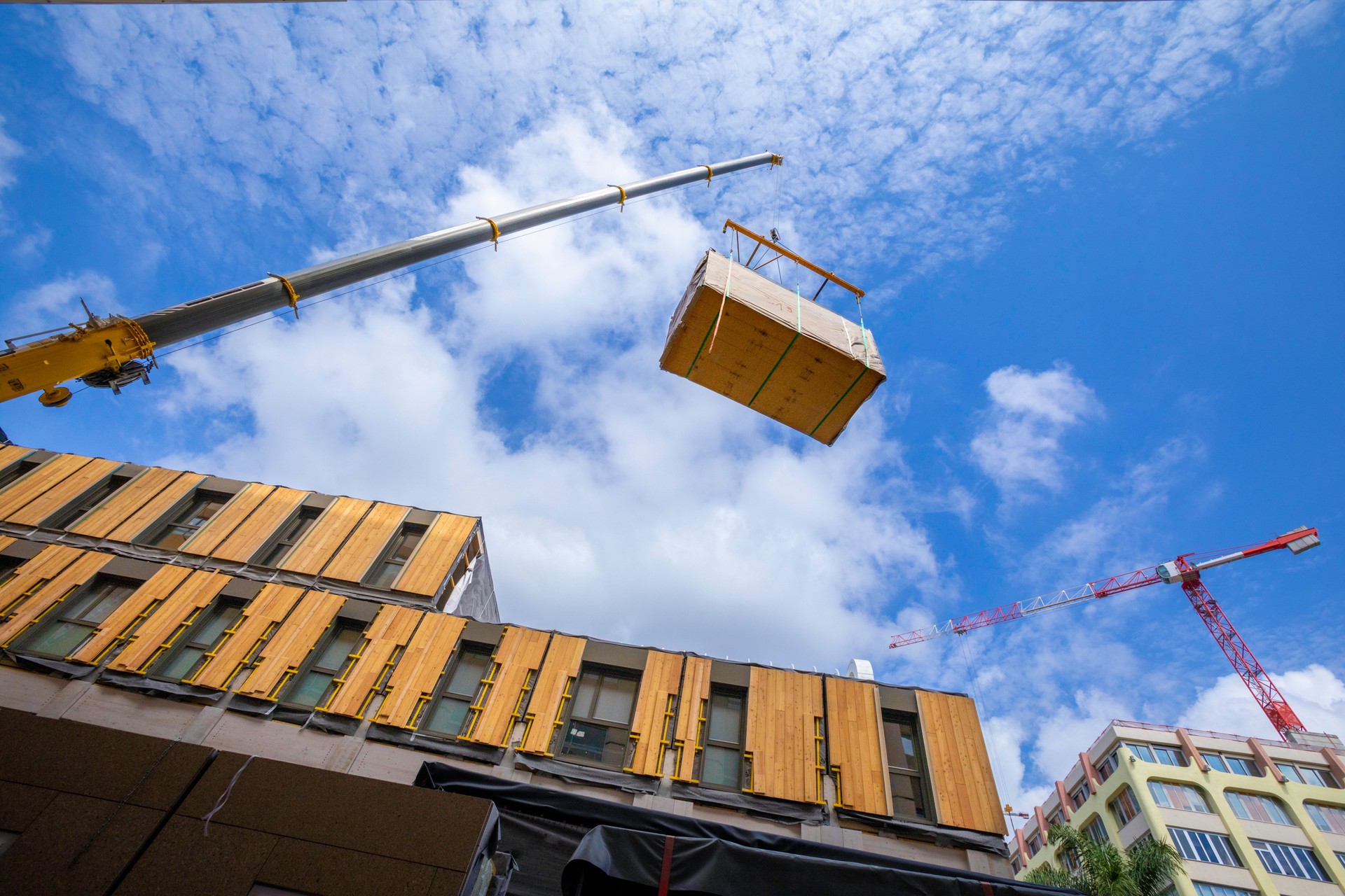 Pre-fabricated modular wood commercial building being assembled with crane